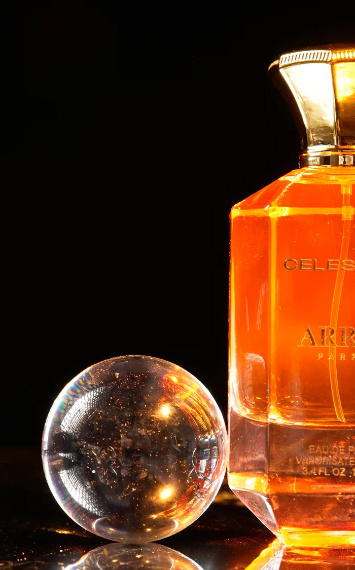 Bottle of arrah oud perfume with glass spheres on a dark background