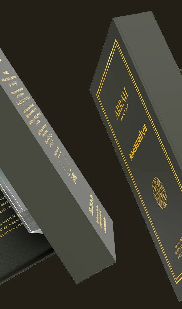 Luxury perfume bottle in an open box with gold text on a dark background