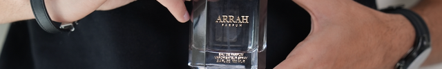 man holding a black and gold Arrah oud cologne bottle