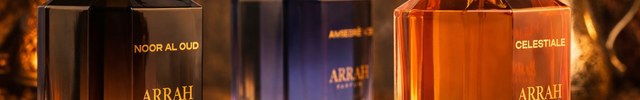 Three Arrah perfume bottles on a decorative tray with spices, against a warm, blurred background.